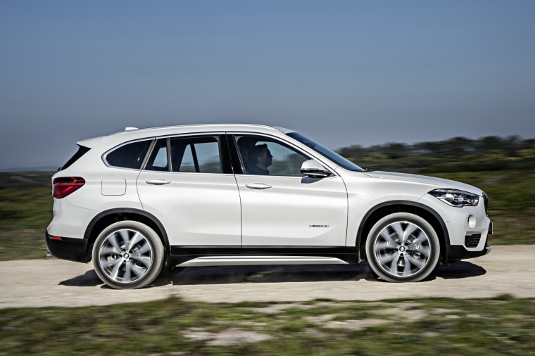 Driving 2019 BMW X1 xDrive28i in Alpine White from a side view